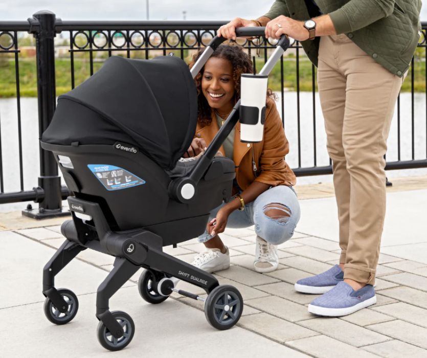 parents looking at their baby in a Evenflo Shyft DualRide Car Seat