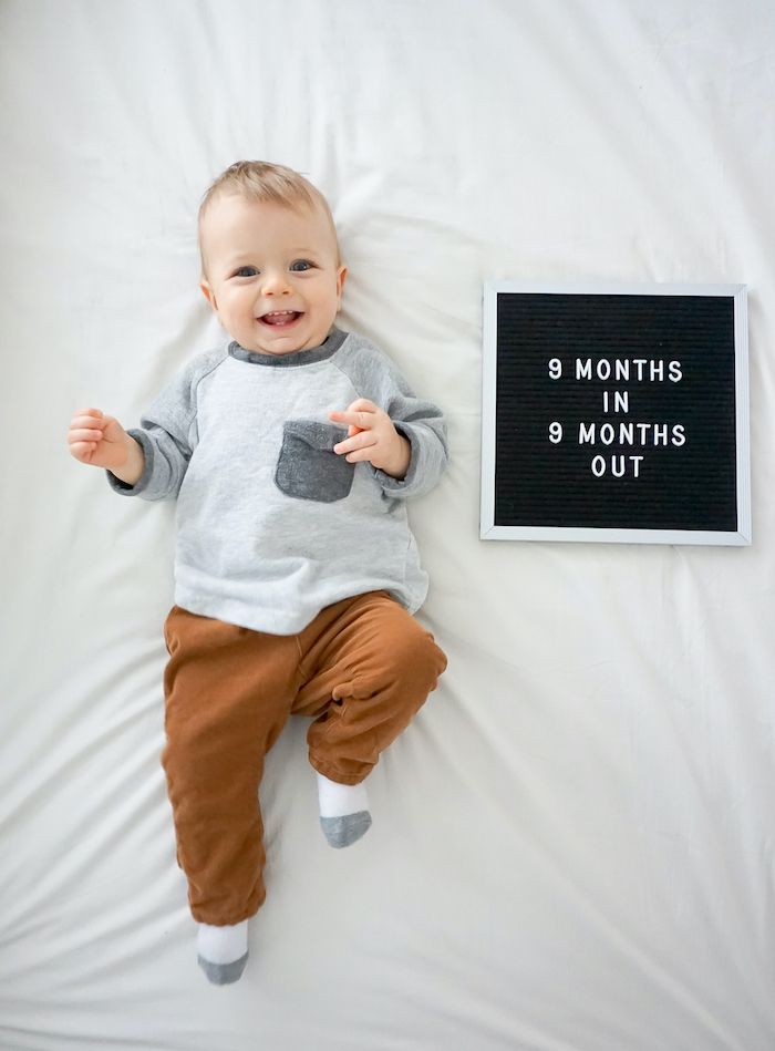 baby boy next to letterboard that says 9 months in 9 months out