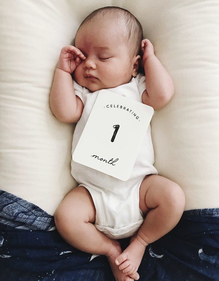 baby with a card that says celebrating 1 month