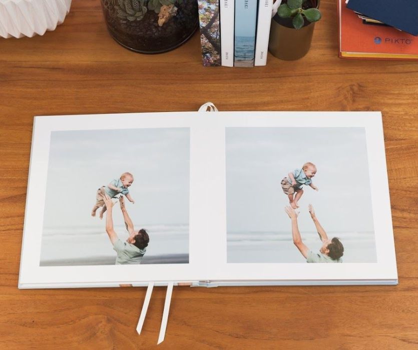 photo album with two photos of a man tossing a baby in the air