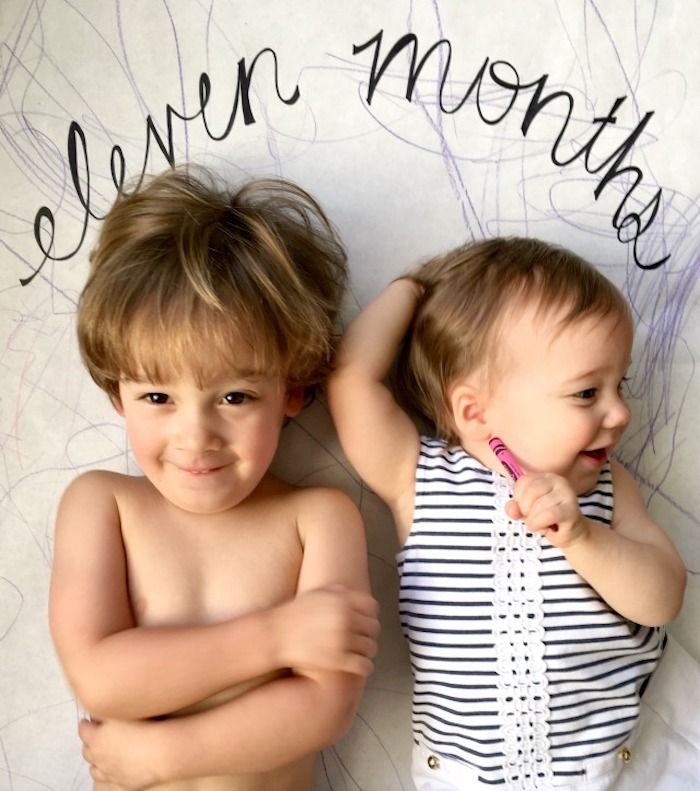 baby with sibling on eleven months backdrop