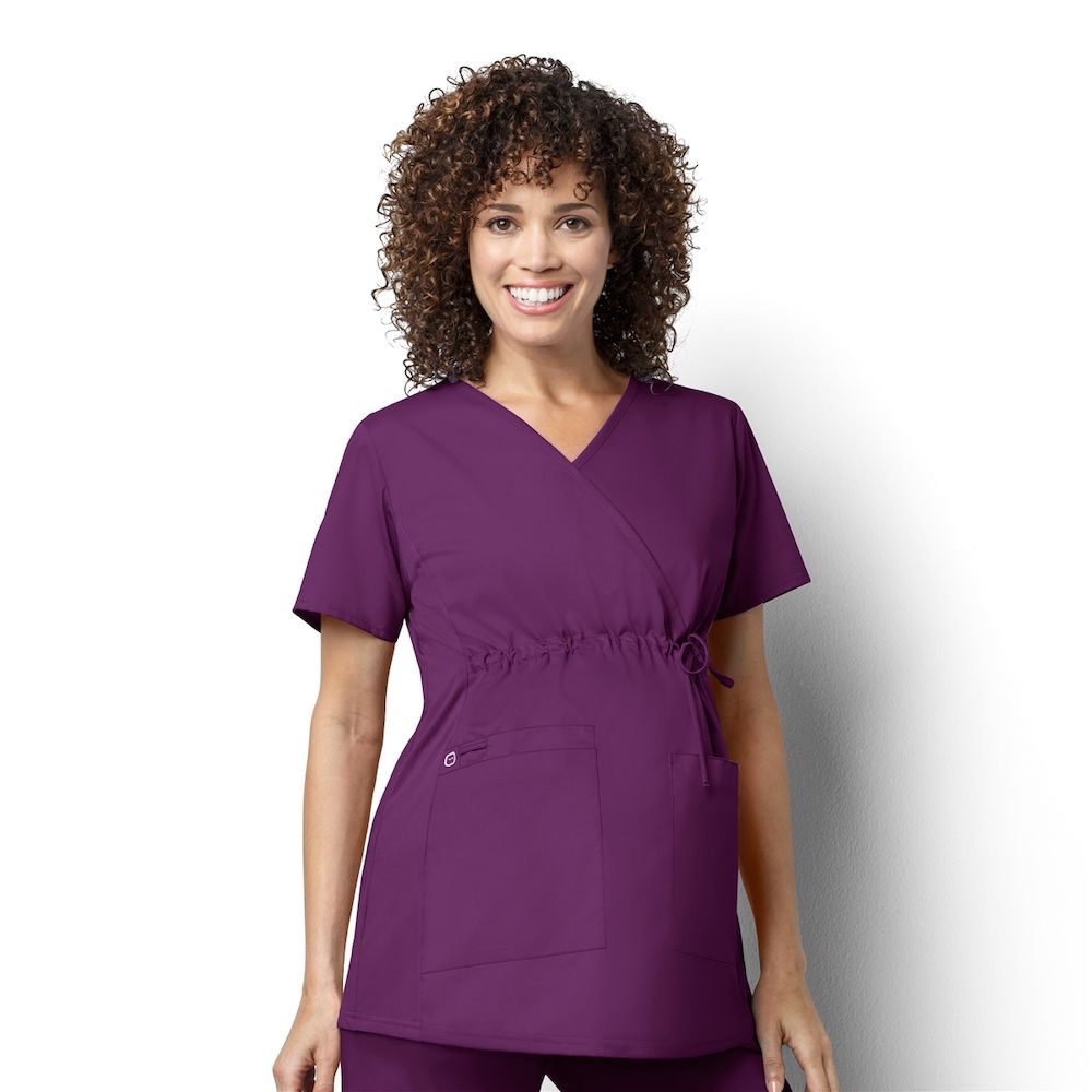 woman wearing dark purple short sleeve maternity scrubs