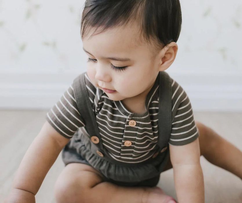 baby wearing a stripe shirt and romper from a Canadian clothing company