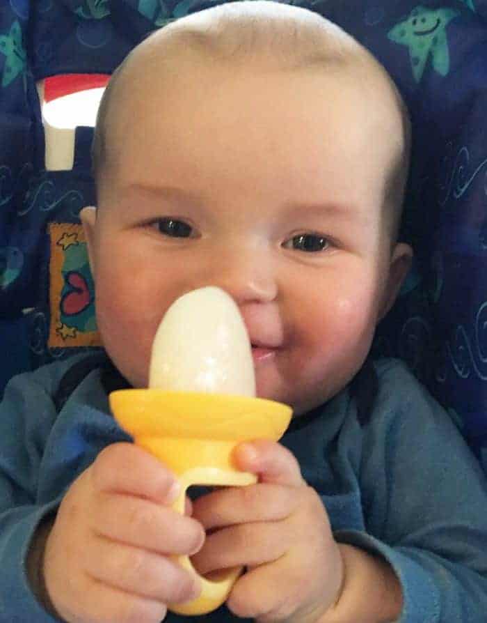 baby holding homemade breastmilk popscicle