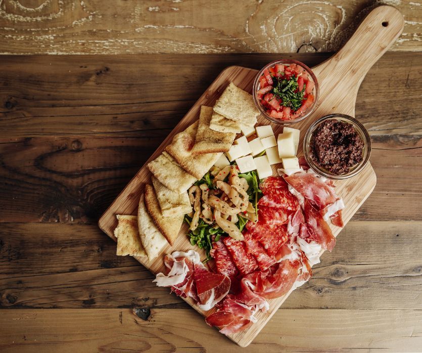 Charcuterie board for new parents with crackers, meats, cheese and dips