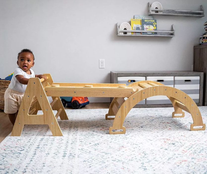 baby climbing a pikler triangle set