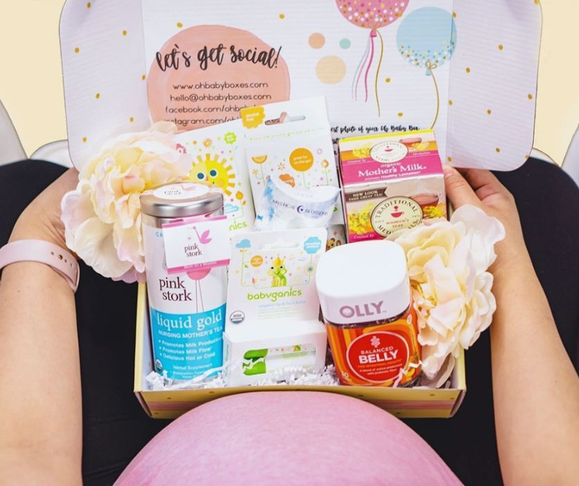 Oh Baby Boxes pregnancy subscription box showing full size items including lip balm, tea, and vitamins