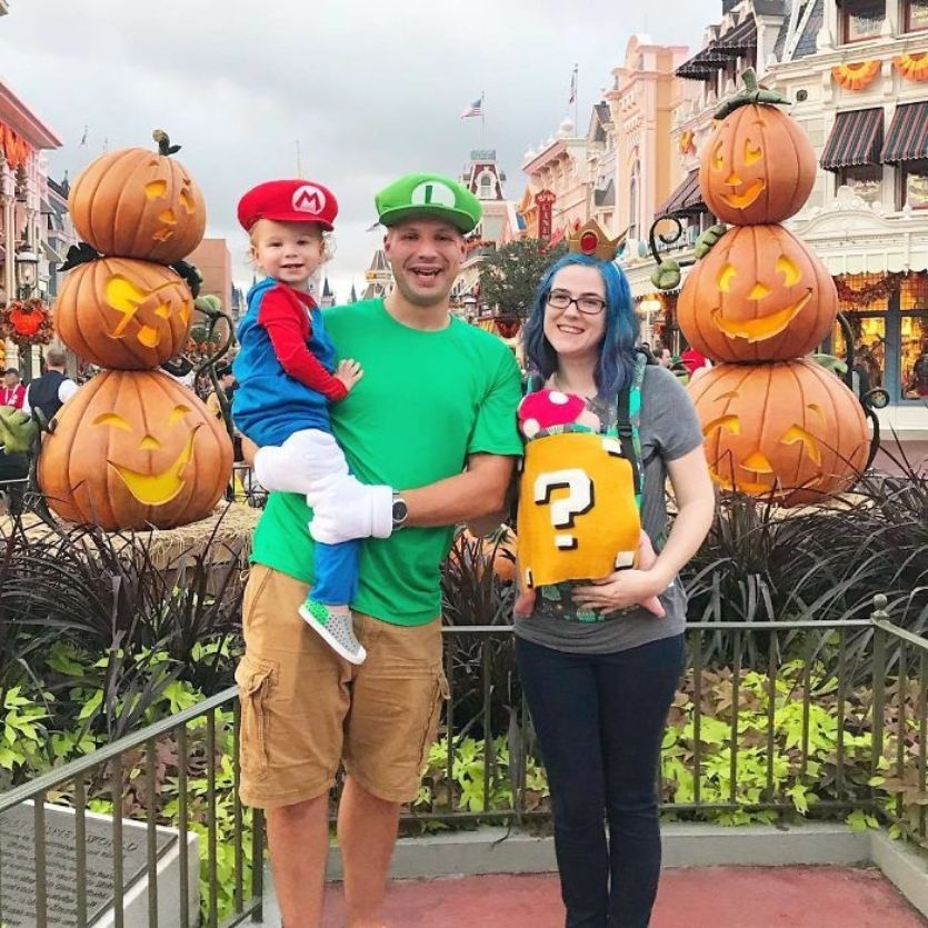 super mario family costume while wearing a baby