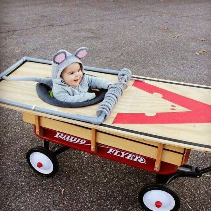 baby wearing a mouse halloween costume sitting in a wagon made to look like a mousetrap