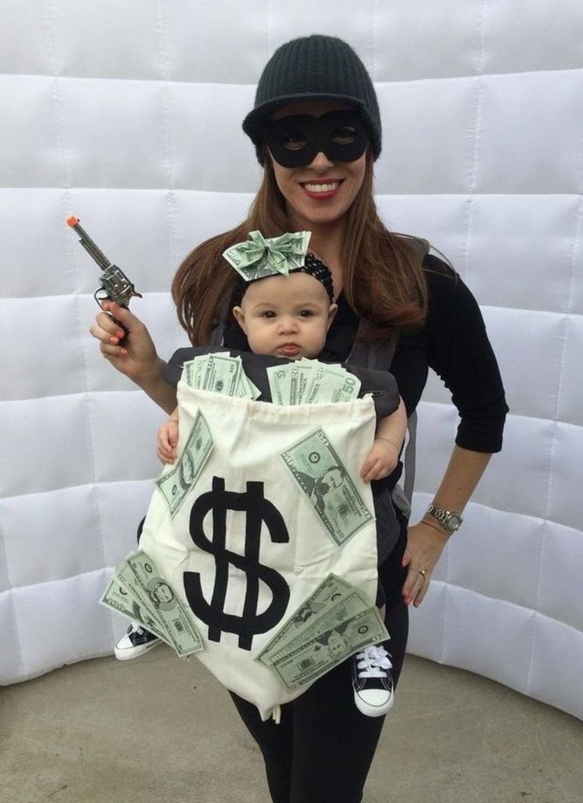 mom is dressed as a bank robber and baby is dressed as a money bag