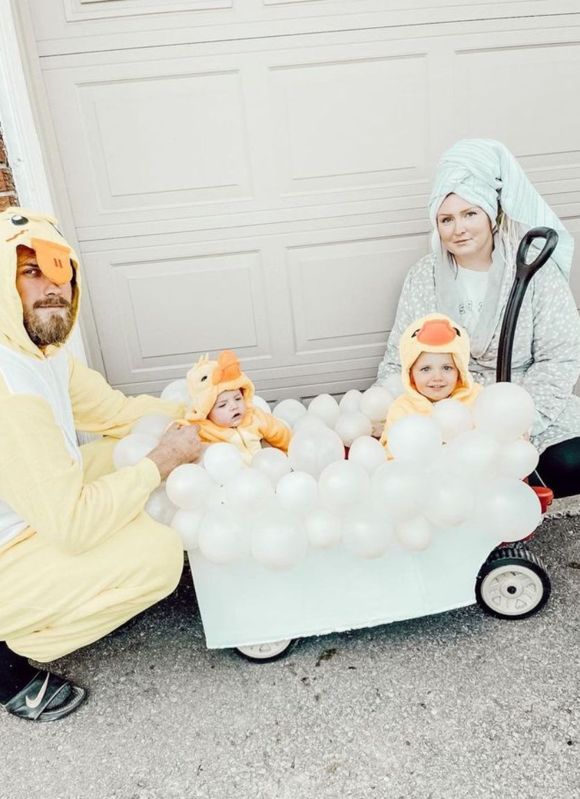 brothers dressed as ducks sitting in a wagon made to look like a bubble bath