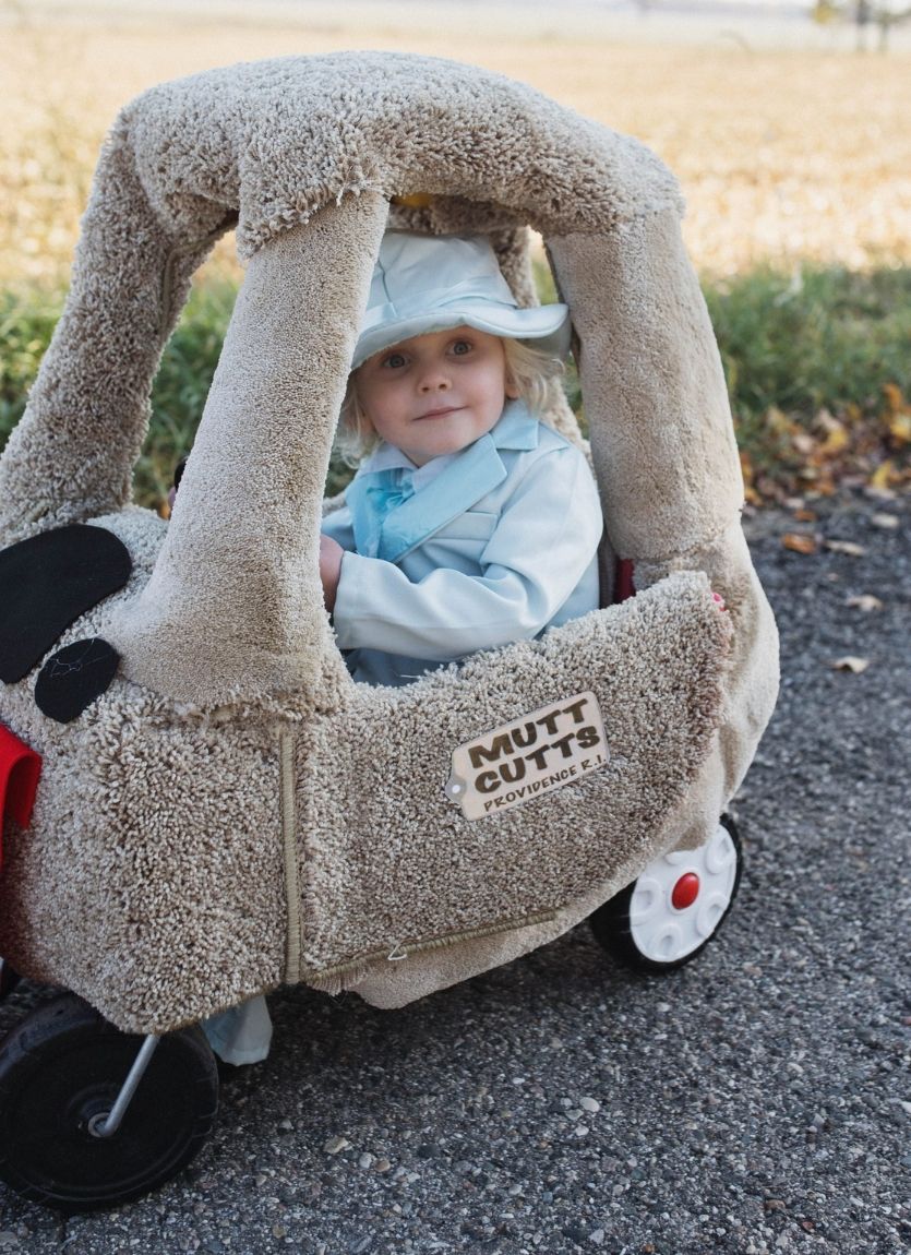 baby sitting in a car made to look like Mutt Cutts Van from Dumb and Dumber