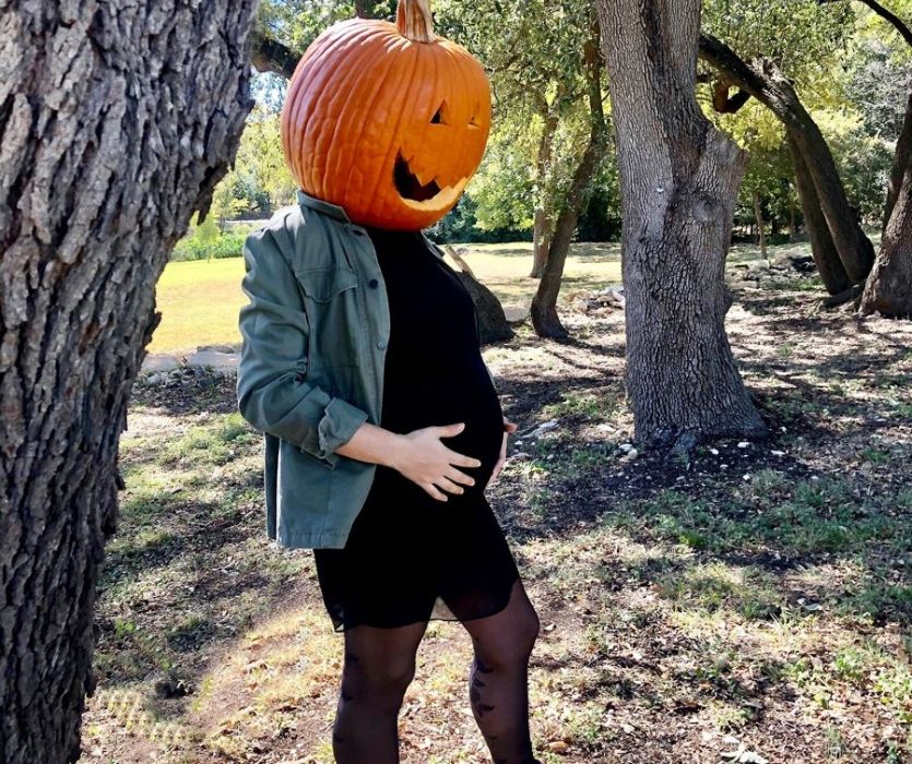 pregnant woman with jack o latern on her head