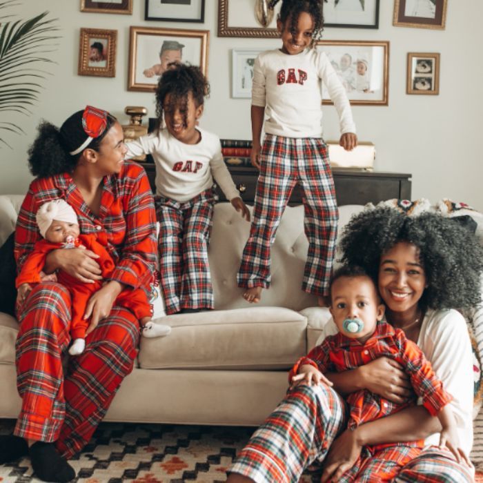 family in livingroom wearing plaid pjs that coordinate