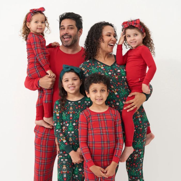 mom and dad with their four kids wearing coordinating red and green chistmas pajamas