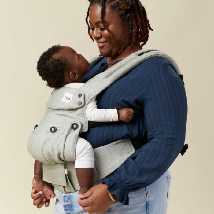 mom holding her baby in a tula baby carrier