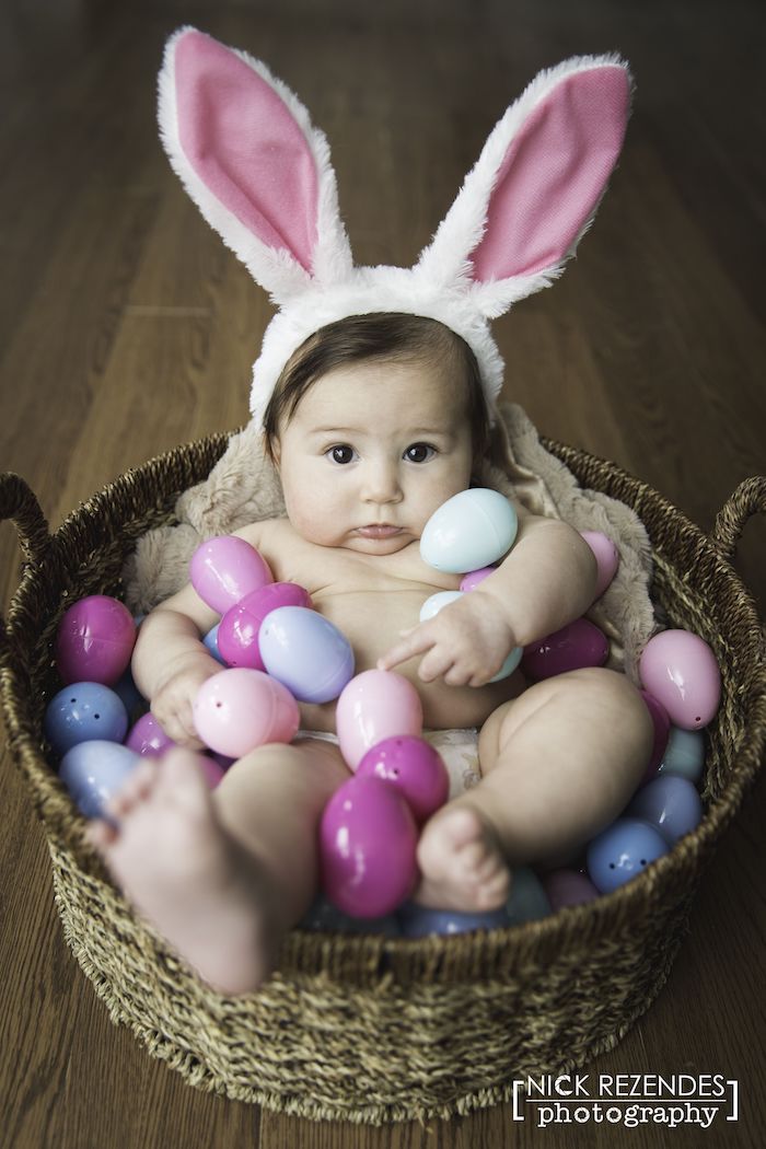 First Easter Photo baby in basket filled with pink and purple eggs
