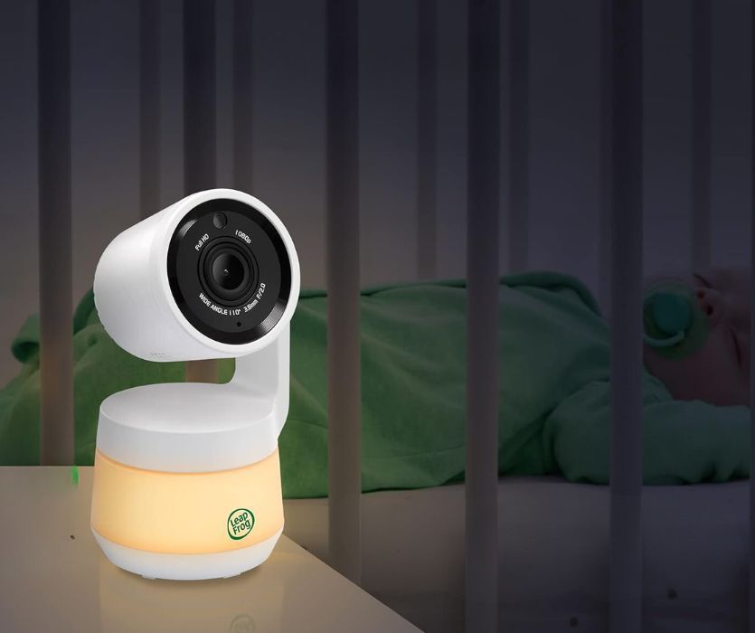 leapfrog baby monitor next to a baby sleeping in a crib at night