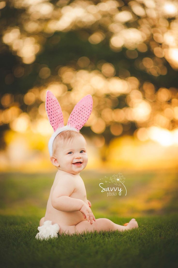 Baby bum first easter photo outdoors on grass wearing bunny ears
