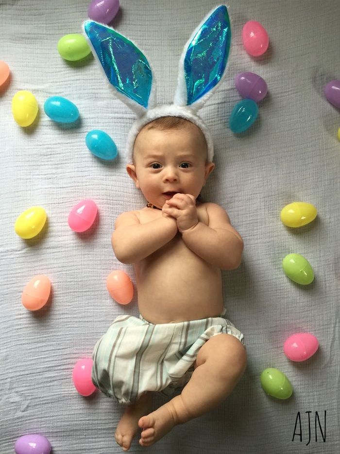 Baby's first Easter photo wearing bunny ears with bright plastic eggs