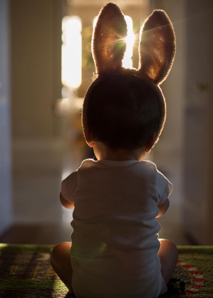 baby wearing bunny ears backlit