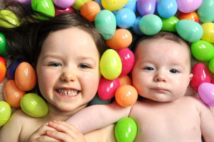 siblings surrounded by plastic easter eggs