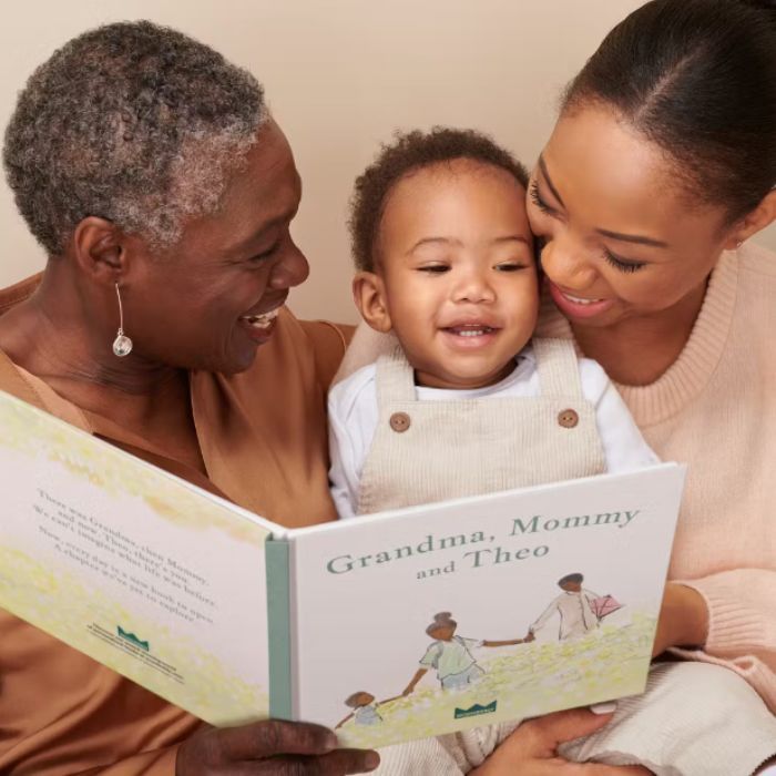 grandma, baby boy and mom looking at a customized picture book