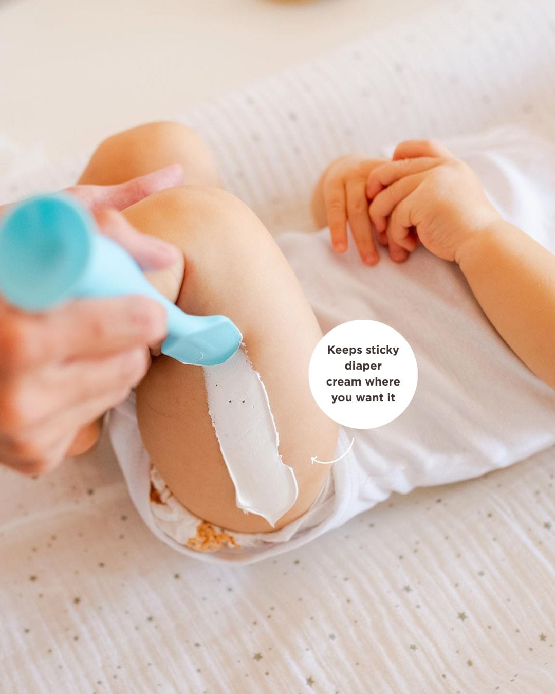 Bumco Baby Bum Brush spreading diaper crean on a baby's leg