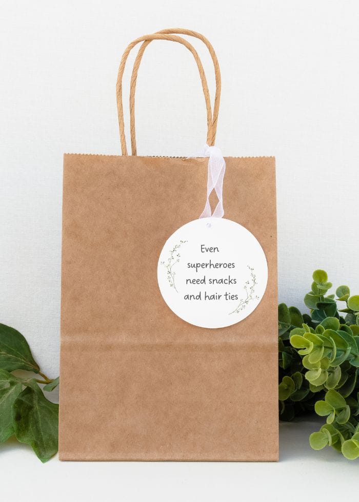 bag with tag that reads even superheroes need snacks and hair ties