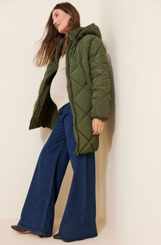 pregnant woman wearing green maternity coat and wide leg denim jean