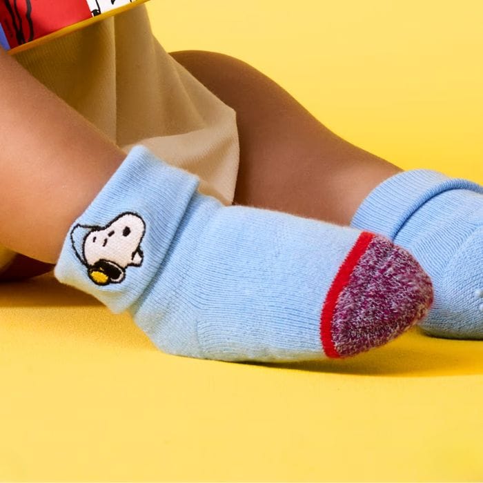 toddler wearing blue socks with snoopy on the cuff