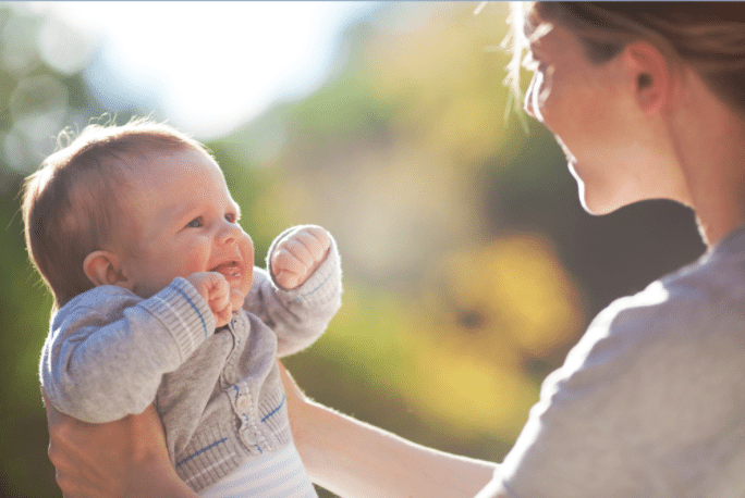 Woman holding baby - what's the best age to have a baby?