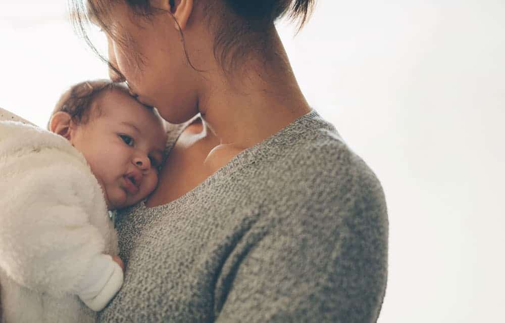mom holding baby getting unsolicited parenting advice
