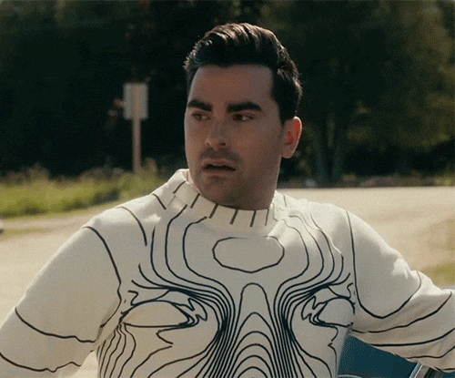 David Rose from Schitt's Creek looking confused while wearing a cream sweater with a black topographical line pattern.