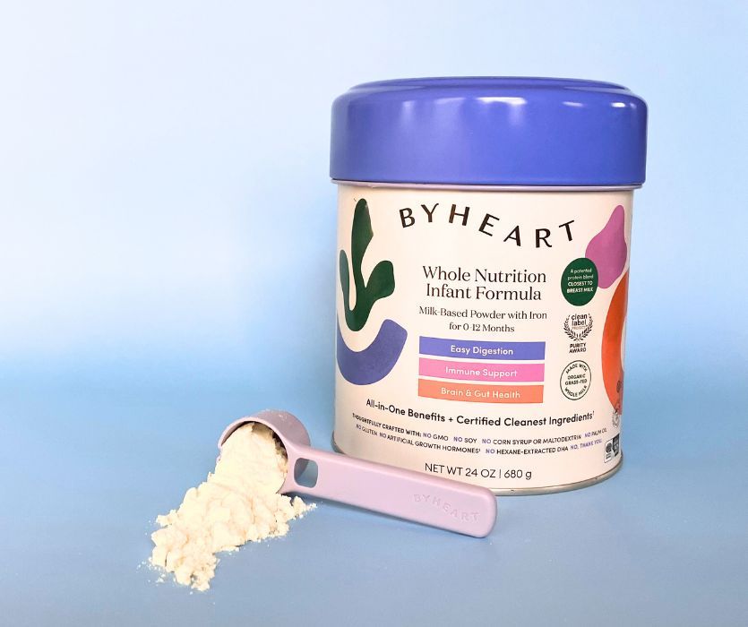 ByHeart Whole Nutrition Infant Formula can next to a purple scoop spilling white powder on a light blue background.