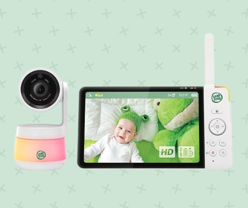 LeapFrog baby monitor and camera displaying a baby in a frog hat on a green background.