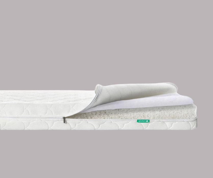 Newton Wovenaire crib mattress with the cover unzipped to reveal the breathable, honeycomb-style internal layer.