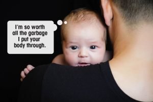A baby peeking over a person's shoulder with a thought bubble saying, I'm so worth all the garbage I put your body through.