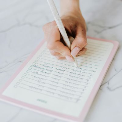 woman's hand checking off baby items on a list