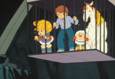 Rainbow Brite, a boy, a white horse, and a small creature trapped in a metal cage.