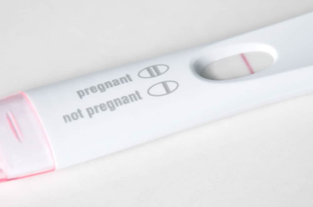 A negative home pregnancy test showing a single pink line next to the not pregnant label.