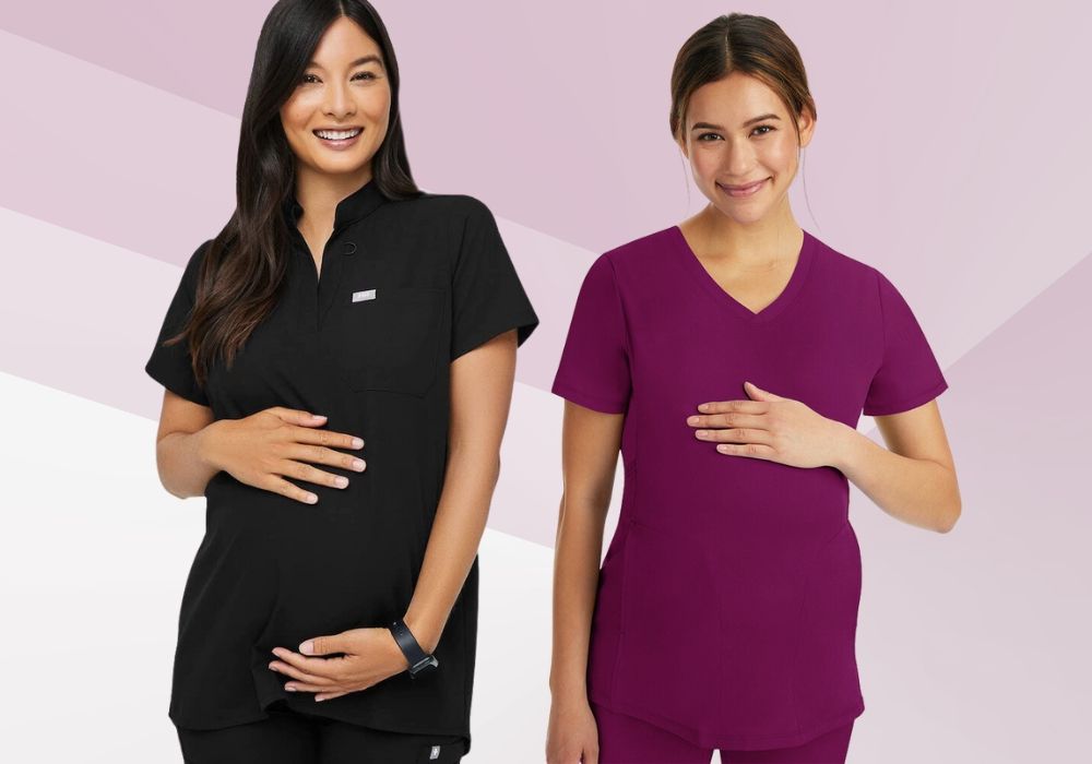 Two smiling pregnant women posing in black and maroon maternity scrub tops against a pink geometric background.