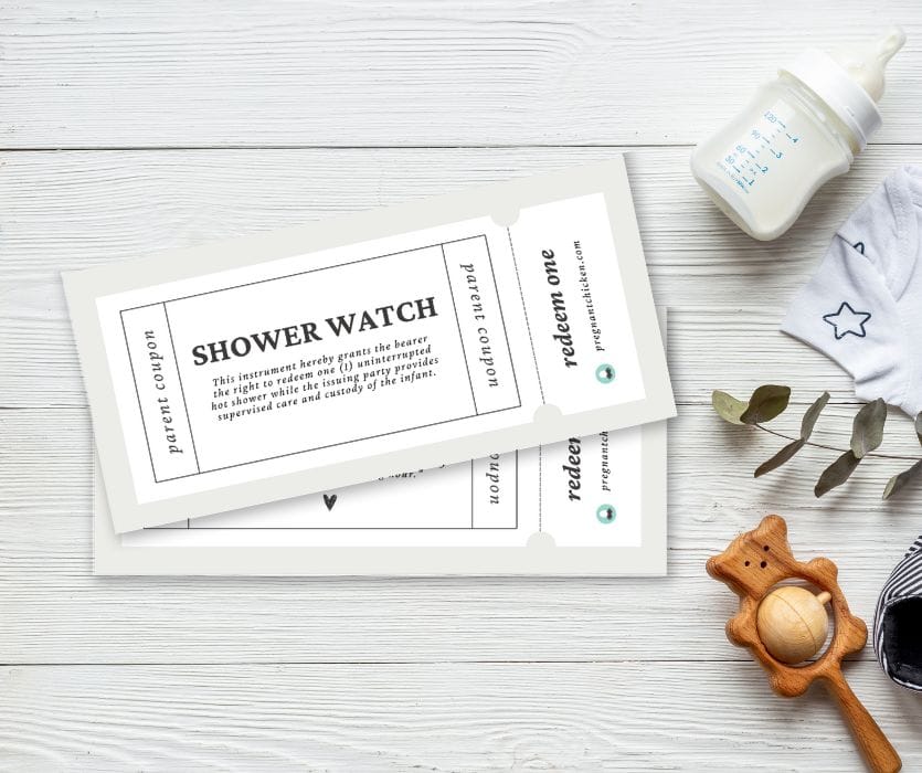 A white Shower Watch parent coupon next to a baby bottle, wooden rattle, and onesie on a white wood surface.