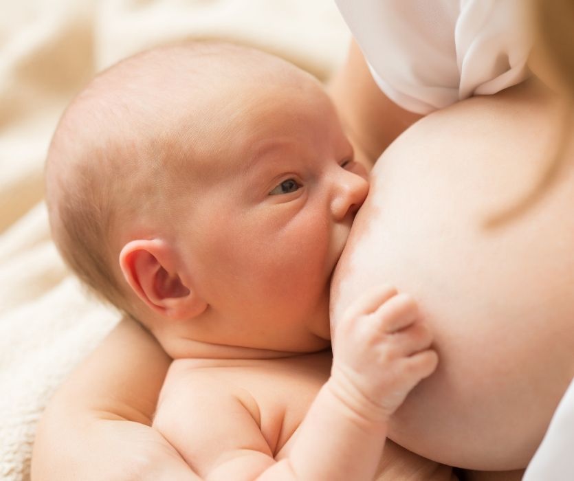 Close-up of a newborn infant breastfeeding.