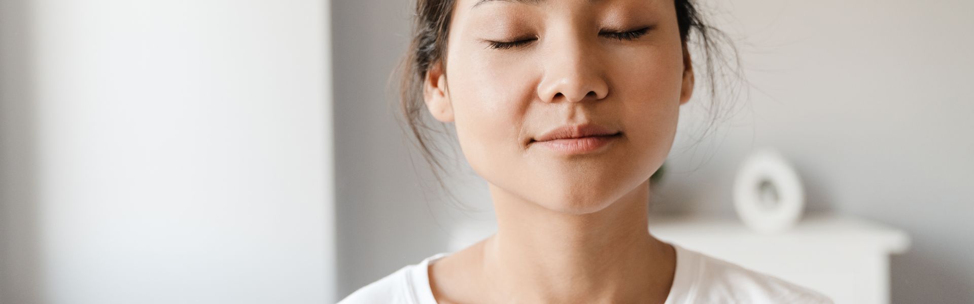 Close-up of a woman with her eyes closed and a calm expression.